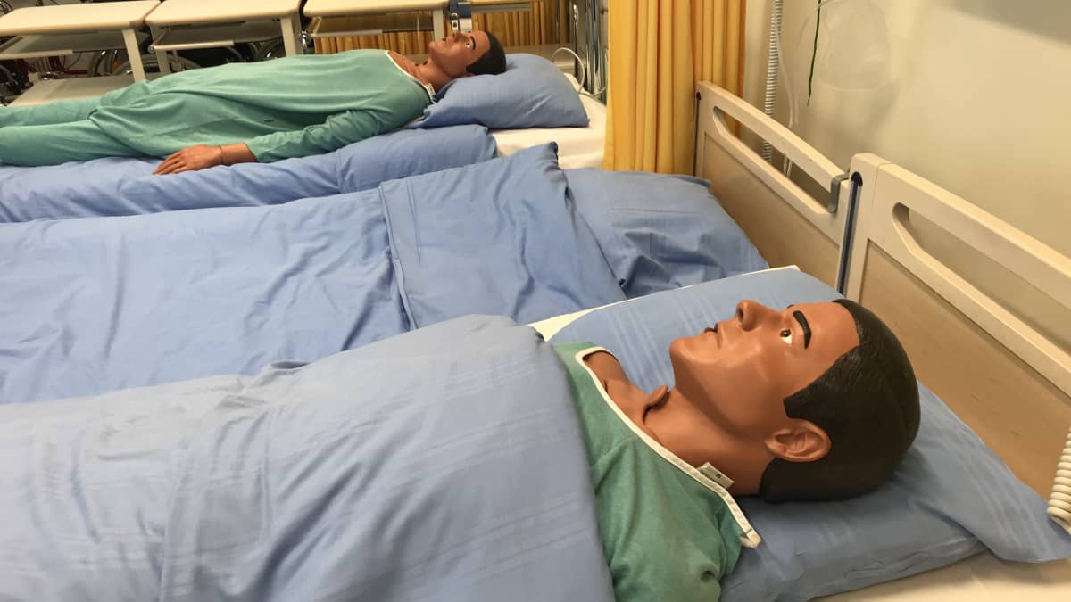 Koulutuskeskus Tredun sairaanhoitoopintojen koulutukseen käytettäviä nukkeja makaan sängyssä..