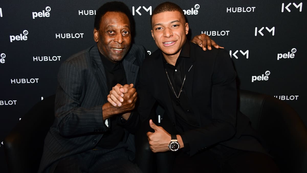 Pelé ja Kylian Mbappe poseeraavat kameralle käsi kädessä.