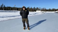 Mies seisoo tyhjällä jääspeedwayradalla.