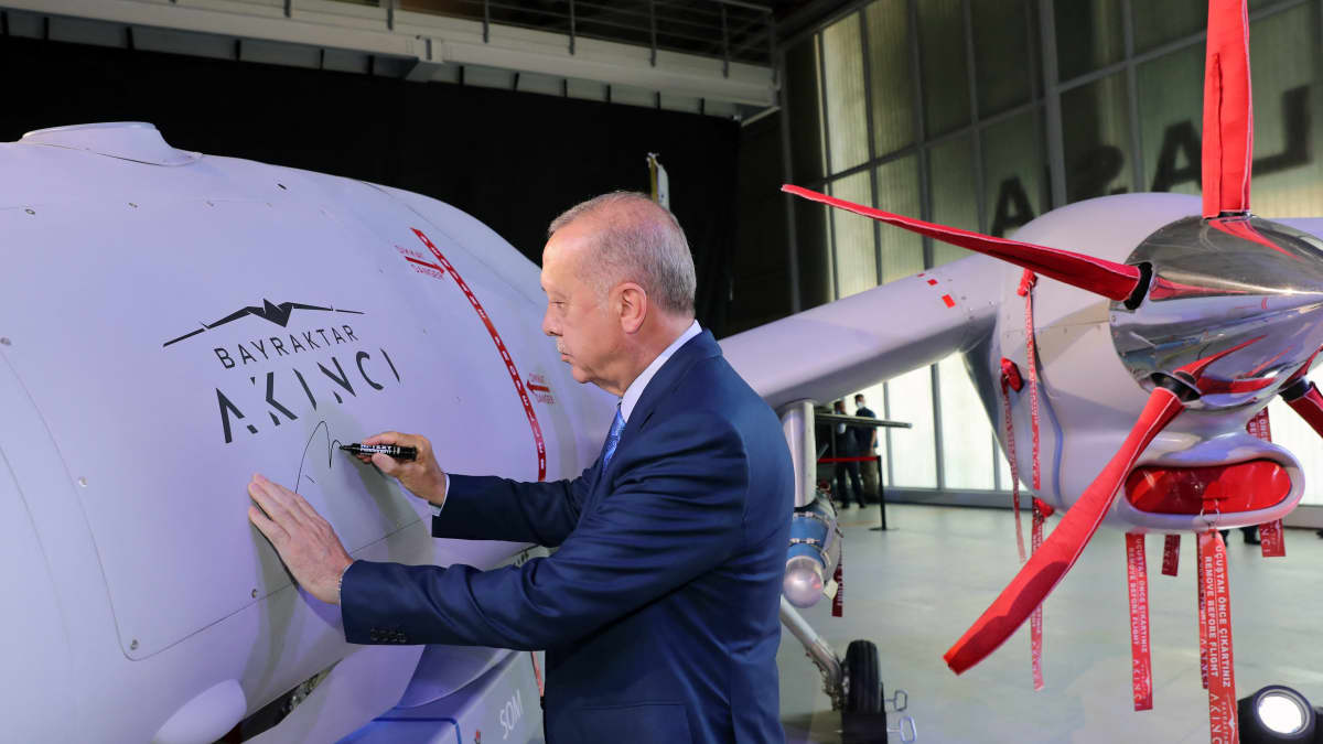 Turkin presidentti Recep Tayyip Erdogan kirjoittaa nimensä turkkilaisen Bayraktarin valmistamaan Akinci-droneen. elokuussa 2021