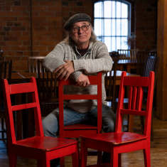 Tom Lindholm ja kolme punaista tuolia.