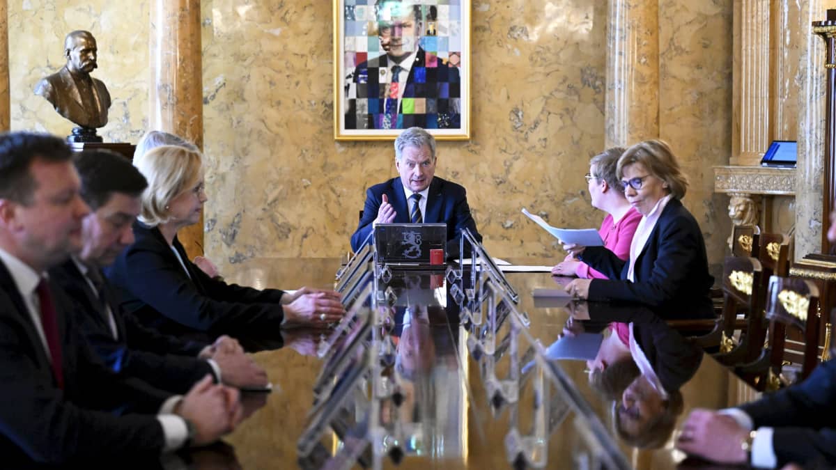 President Niinistö sitter vid ändan av ett långt bord. Runt bordet sitter ministrar.