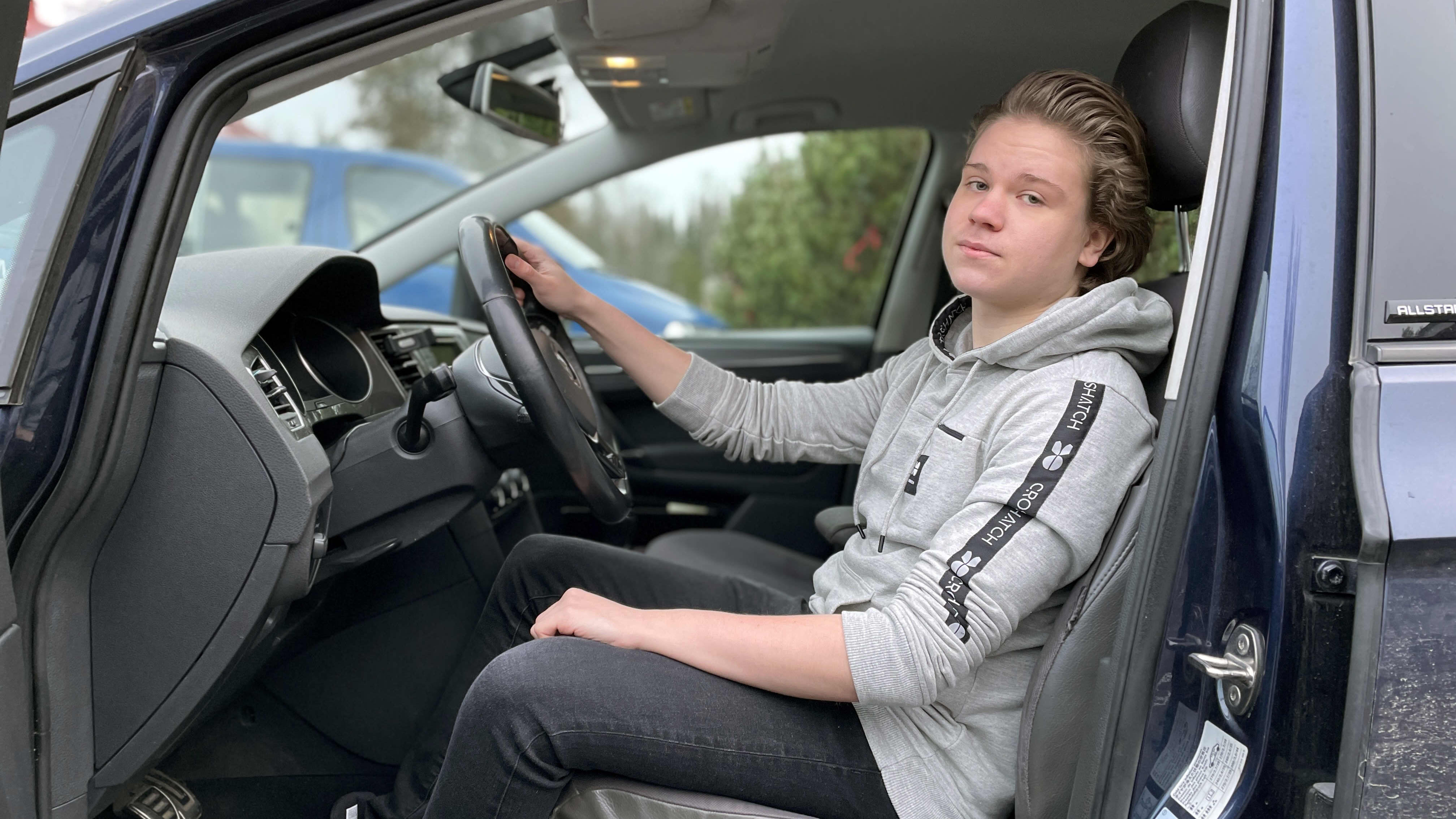 Lukion oppilas Veeti Koski istuu opetusautossa kuljettajan penkillä.