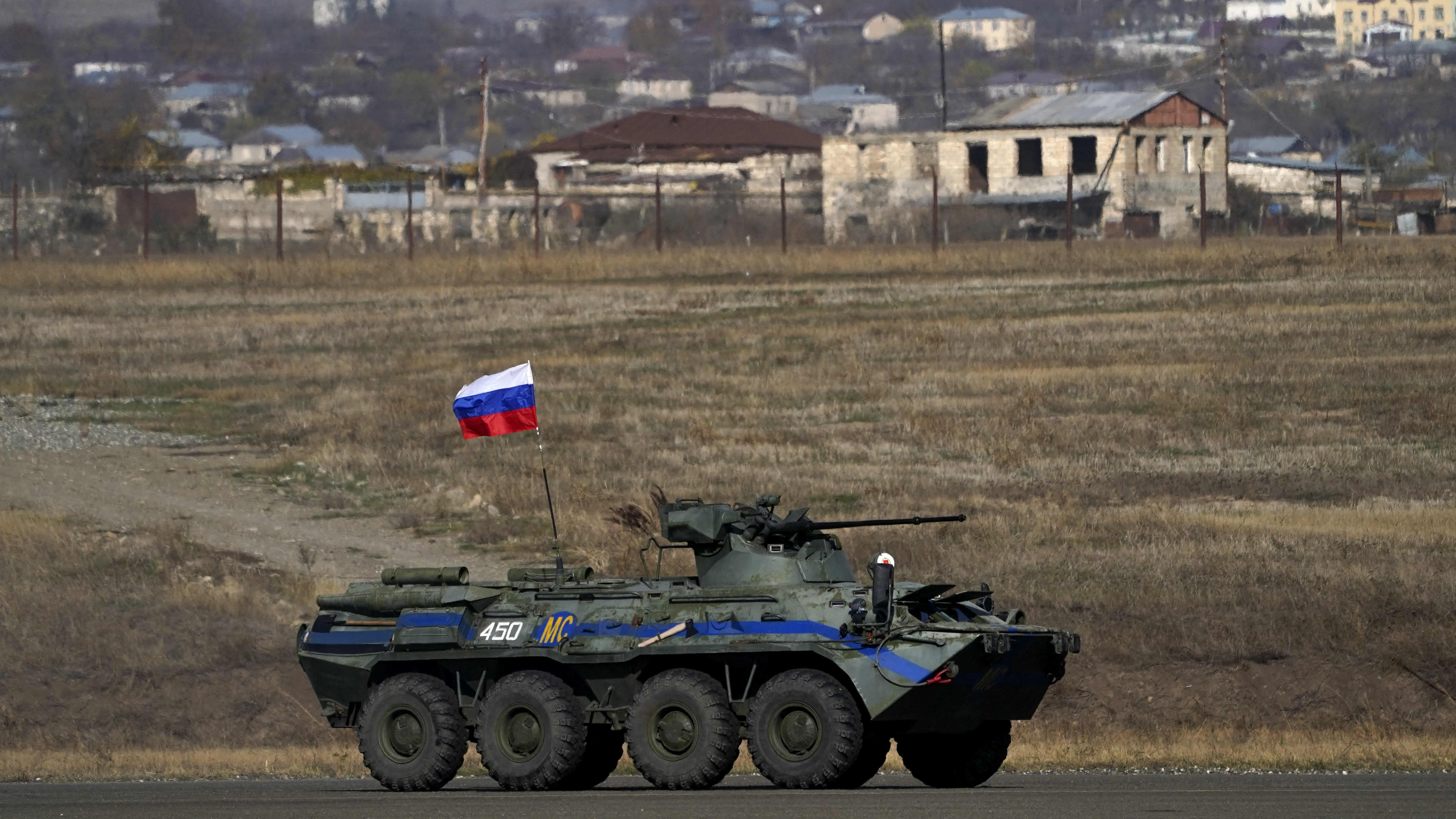 Kuvassa näkyy venäläinen panssariajoneuvo ja taustalla pieni vuoristokylä.