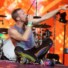 Coldplayn Chris Martin istuu lavalla Milanon konsertissa kesäkuussa.