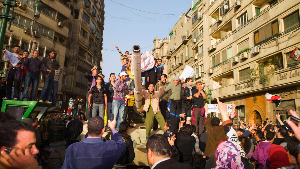 Hallituksen vastaiset mielenosoittajat juhlivat armeijan tankin päällä Kairon keskustassa Egyptissä Tahririn aukiolla 29. tammikuuta 2011.