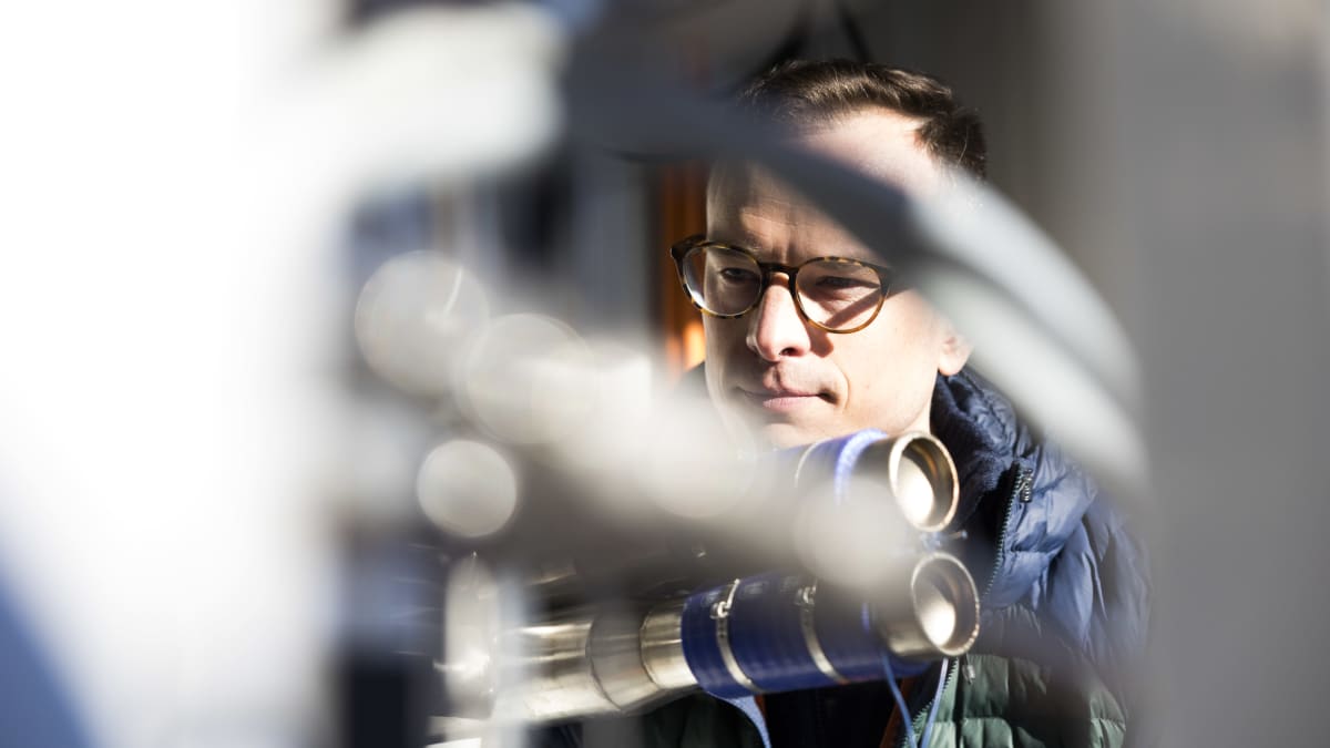 VTT:n energia-alueen tutkimusjohtaja Antti Arasto tarkastelee vetyä tuottavaa polttokennoa Otaniemen laboratorion pihassa.