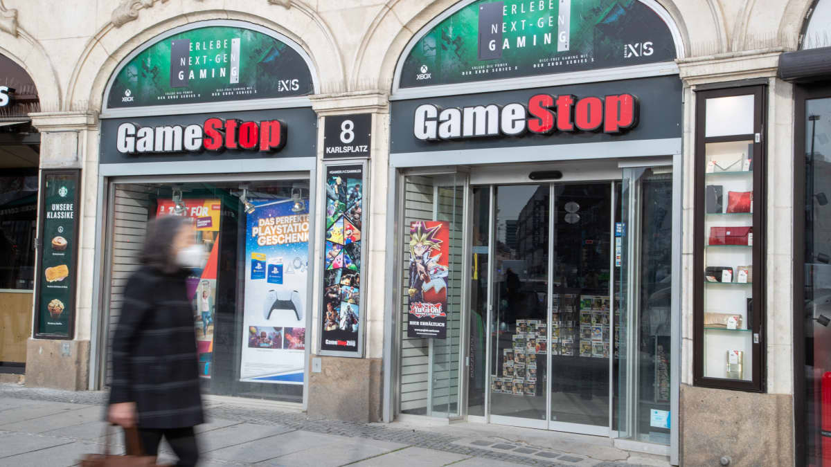 Ihminen kävelee kadulla GameStop liikkeen ohi.