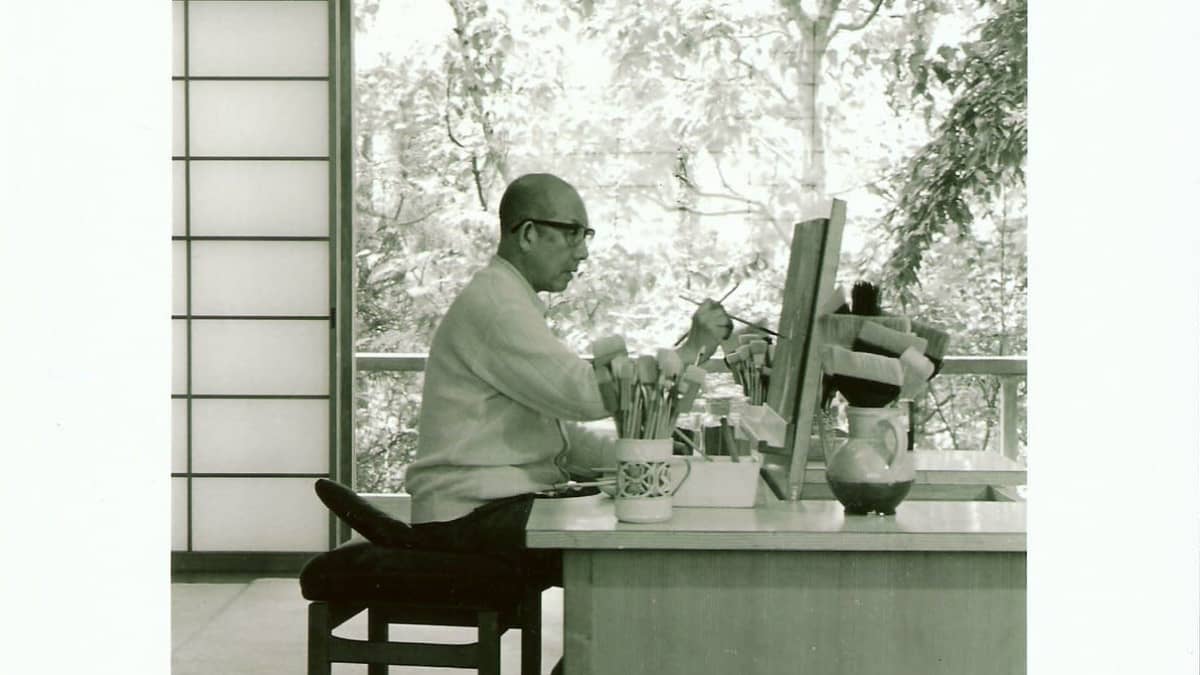 Kaii Higashiyama istuu työpöydän äärellä kotiateljeessaan Ichikawassa vuonna1988.