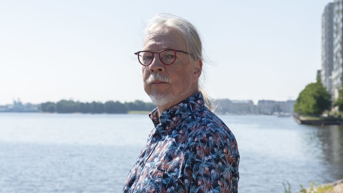 Ydinvoiman mallinnuksen professori Juhani Hyvärinen poseeraa kameralle meren äärellä.