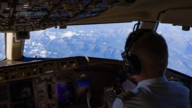 En bild bakifrån av en pilot i en cockpit.