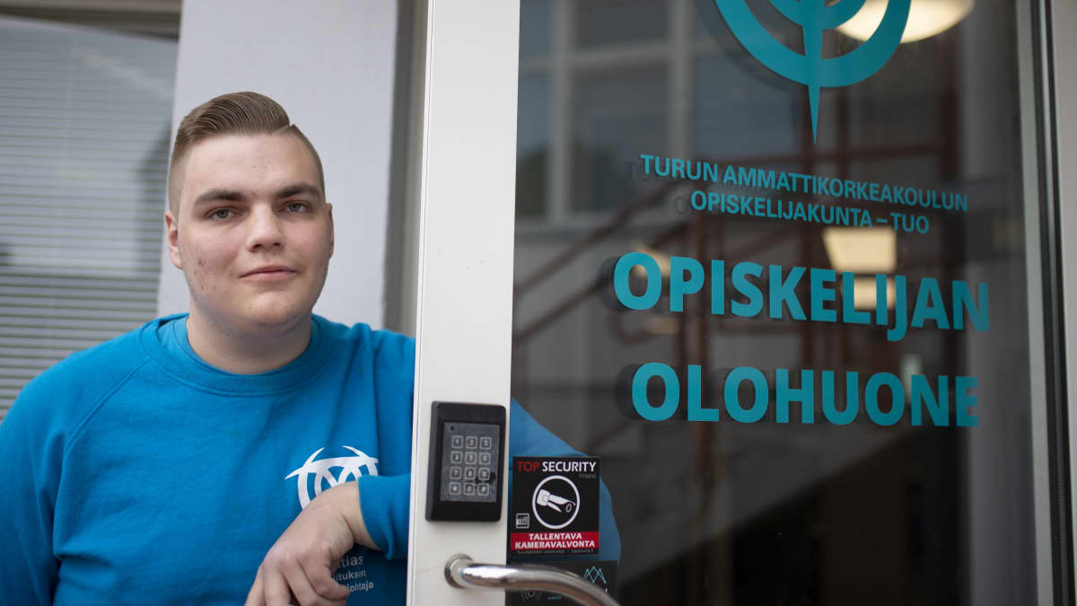Turun ammattikorkeakoulun opiskelijakunnan hallituksen puheenjohtaja Matias Sillanmäki nojaa TUOn toimiston oveen.