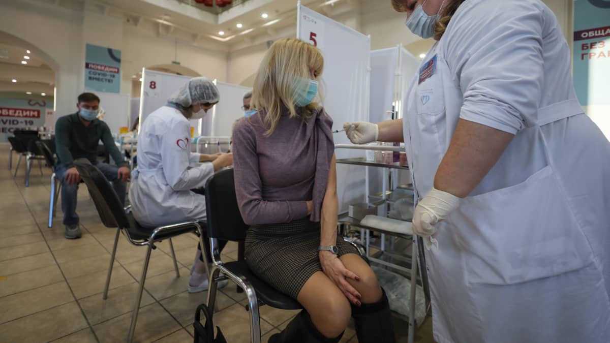Nainen saa Sputnik-rokotteen rokotuspaikalla Moskovassa. 