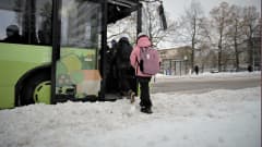 Lapset koulumatkalla nousevat linja-autoon.