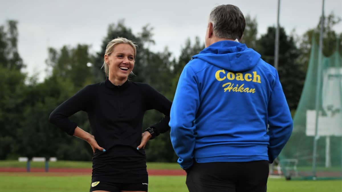 Nina Chydenius samtalar med tränaren Håkan Prest på sportplan.