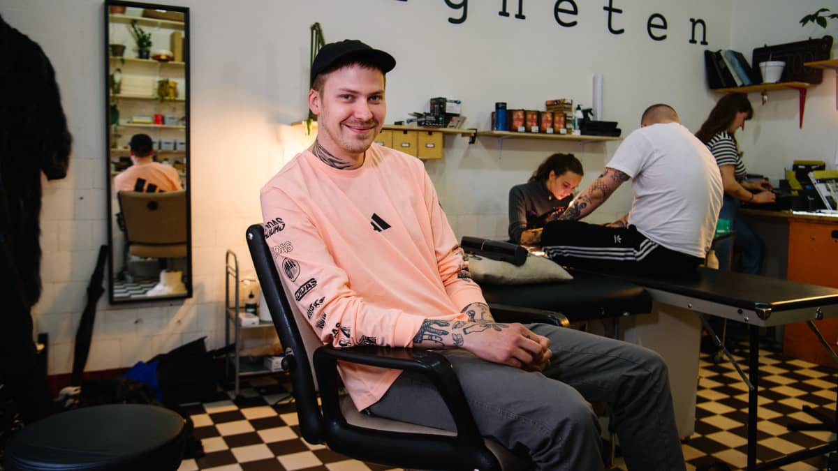 mies tuolissa tatuointistudiossa