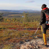Retkeilijä Muonion Äkäskerolla, Ylläs-Pallastunturin kansallispuistossa maaruskan värittämässä maisemassa.