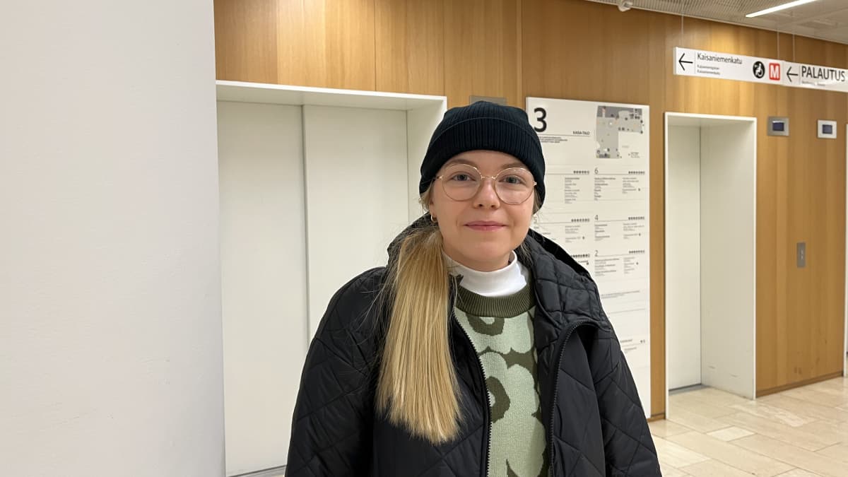 Opiskelija Elsa Halme Helsingin yliopiston pääkirjastossa. Taustalla kirjaston hissit.