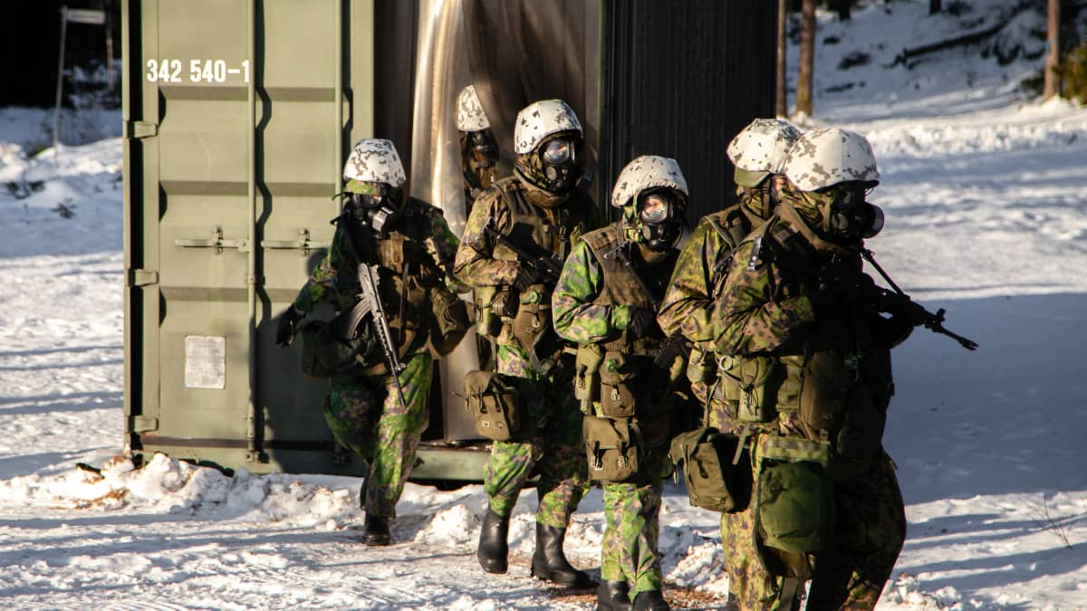 Alokkaita tulee ulos kontista tiiviystestistä kaasunaamarit päällä..