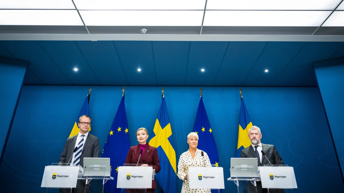 Neljä henkilöä tiedotustilaisuudessa. Taustalla Ruotsin ja EU:n liput.