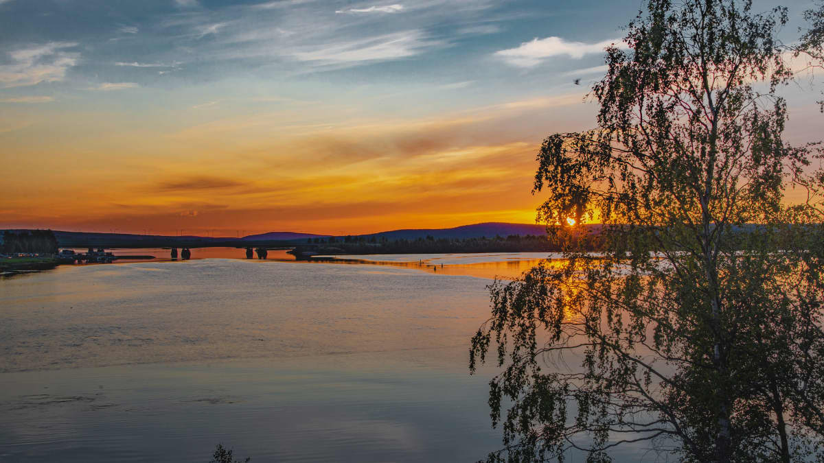 Keskikesän yötön yö Rovaniemellä, maisema Lainaalta joelle kohti nelostien siltaa.