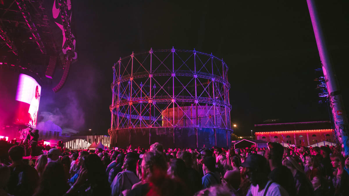 Flow Festivalin päälavan edessä yleisöä Wiz Kidin keikalla violetissa valossa. Ilta on pimentänyt muuten festivaalialueen. 
