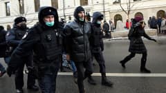 Venäläiset poliisit vievät pidätettyä miestä pois mielenosoituksesta.