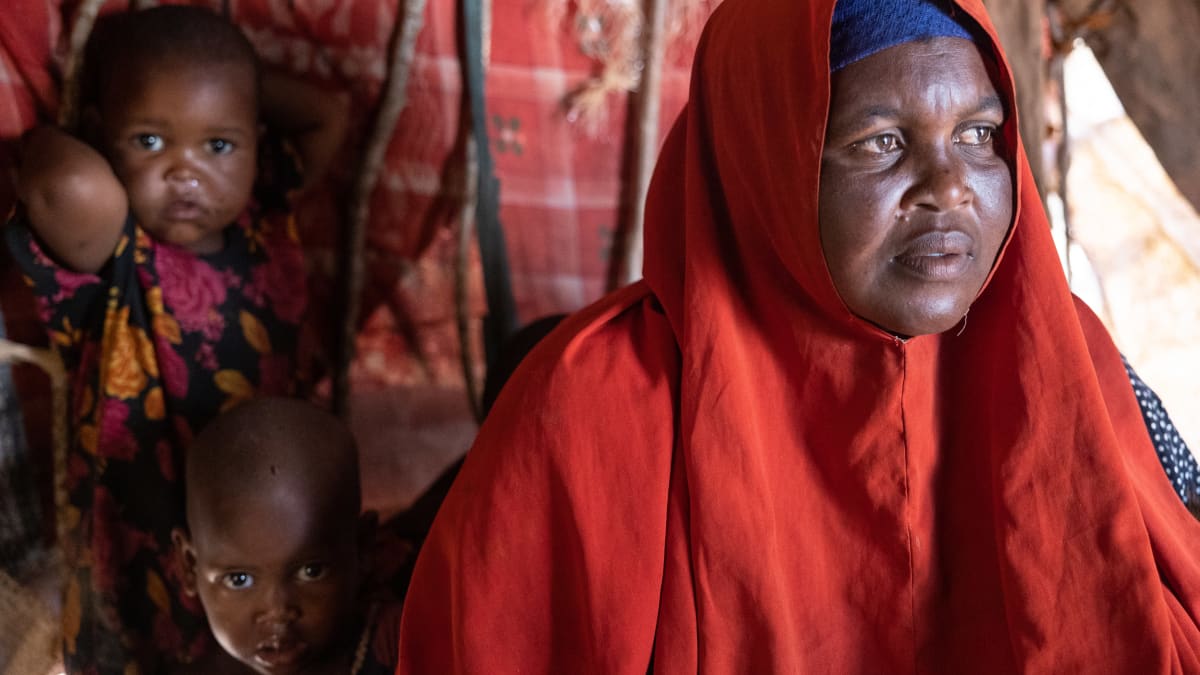 Somalialainen pakolaisäiti Adey Isak teltassa kahden lapsensa kanssa surumielisen näköisenä. 