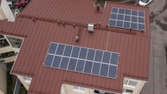 Aurinkopaneelit kerrostalon katolla.