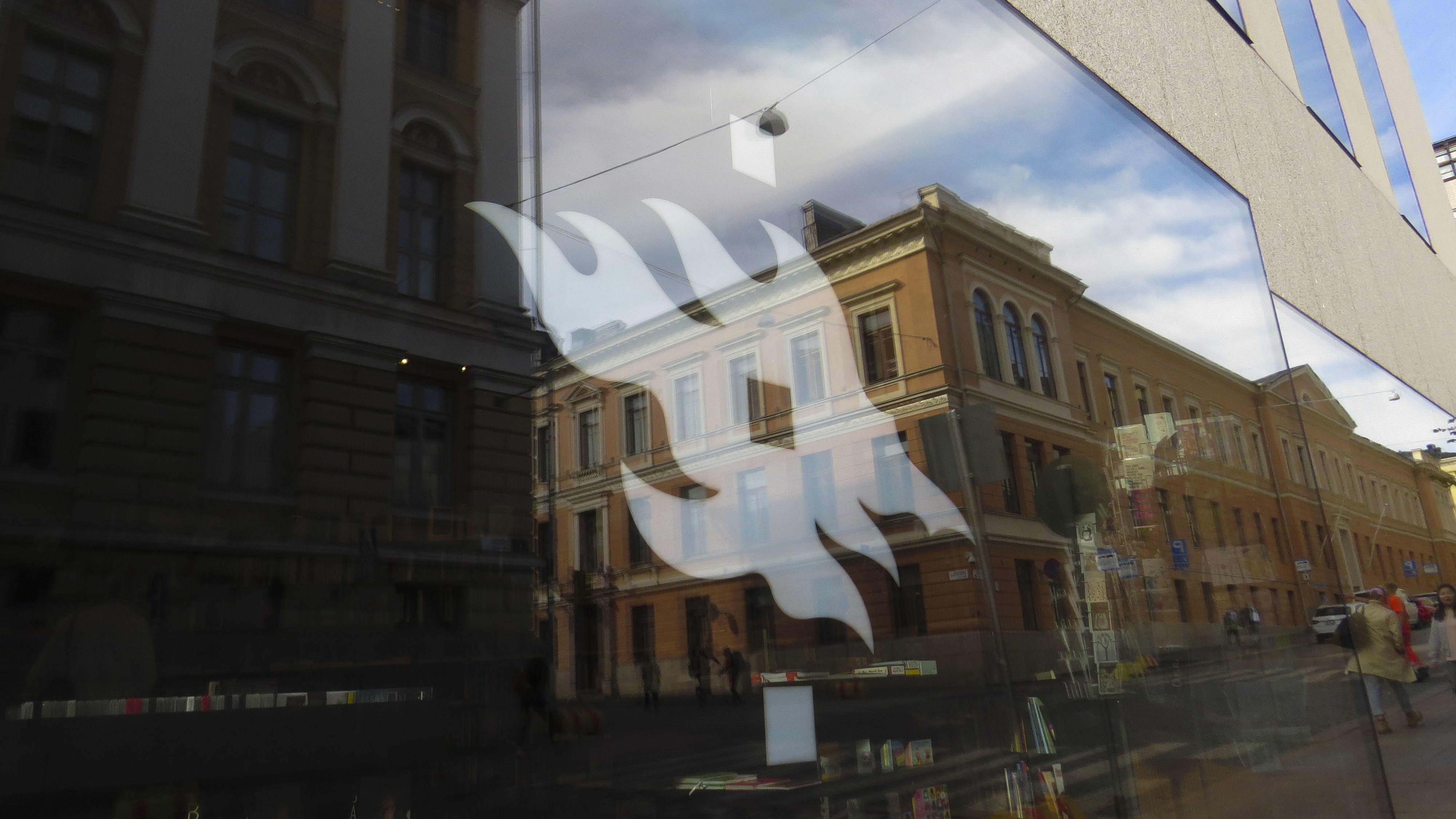 Helsingin yliopiston logo rakennuksen ikkunassa.