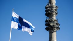 Kuvassa liehuu Suomen lippu, taustalla näkyy Pasilan linkkitorni.