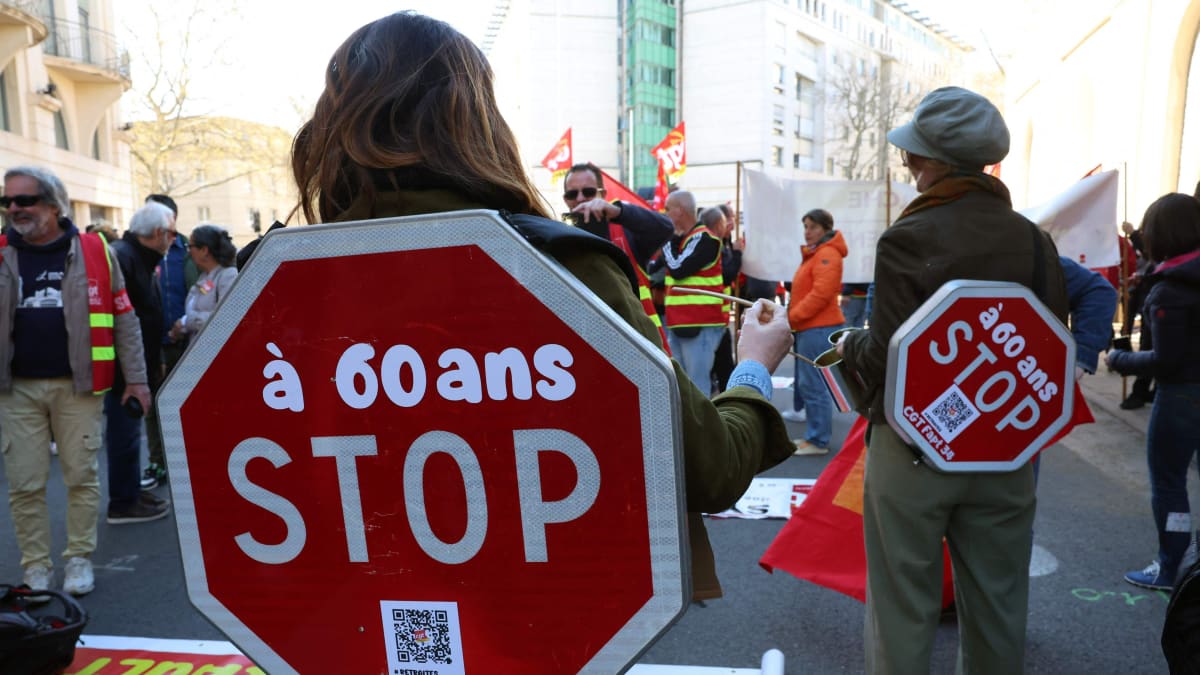 Mielenosoittajat kantavat mielenosoituksen aikana liikennemerkkejä, joissa lukee "At 60, STOP".