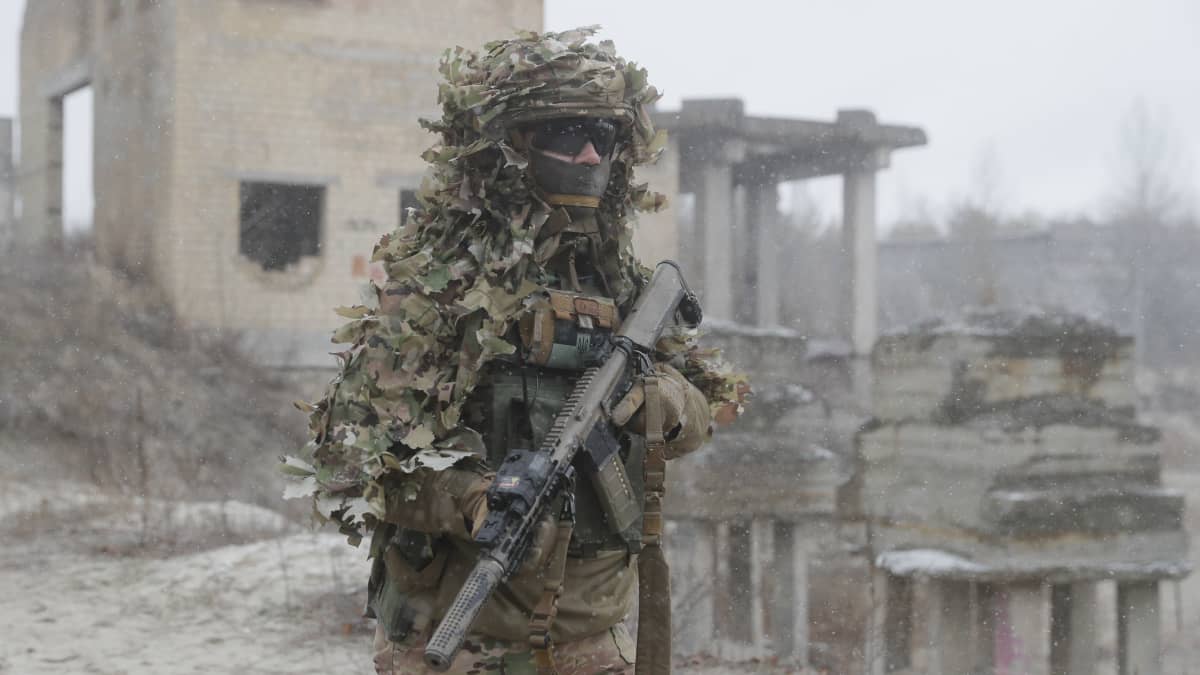 Ukrainalainen sotilas seisoo maastopuvussa raunioiden edessä Kiovan lähellä.