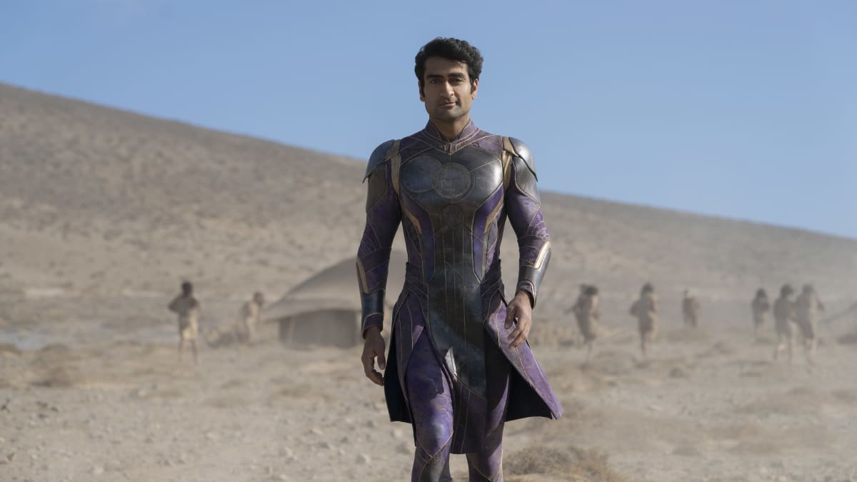 Supersankari Kingo elokuvassa Eternals. Kingo kävelee violetissa asussaan autiomaassa.