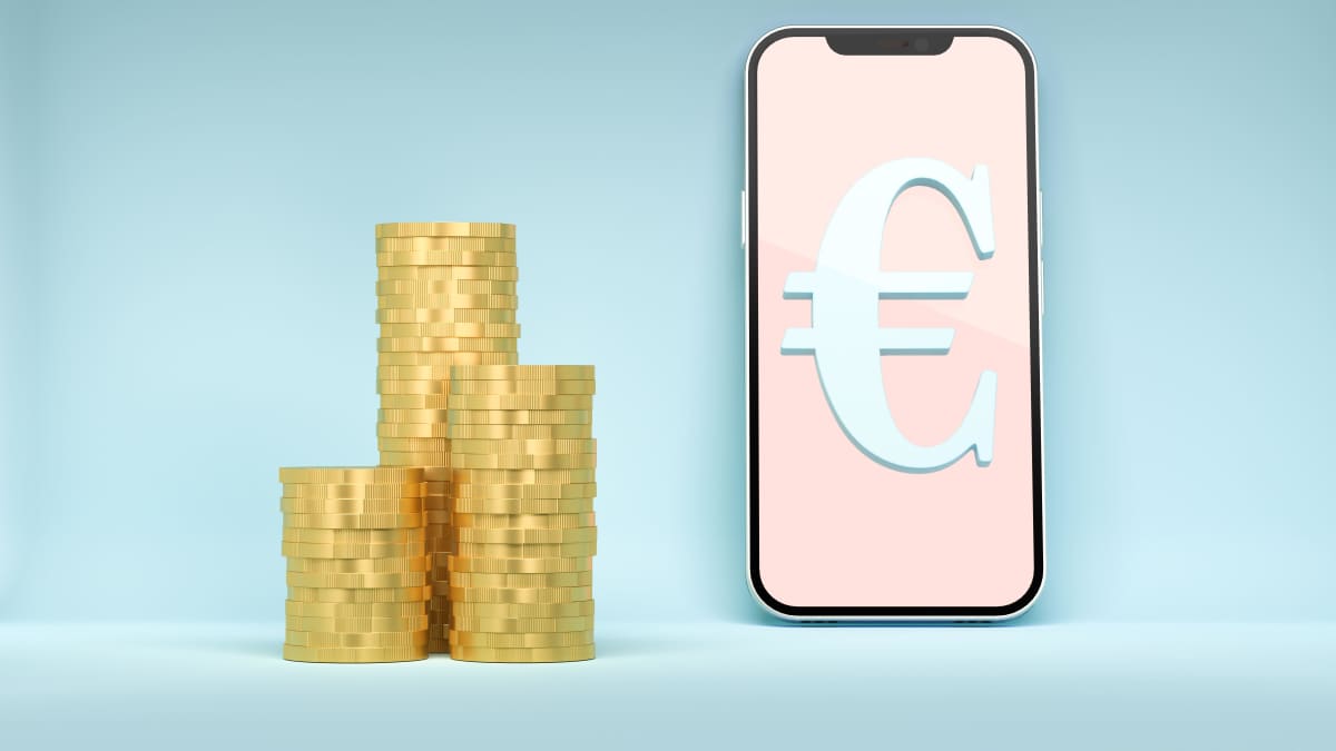 Euron kolikoita pinossa ja digitaalinen euro eli euron symboli matkapuhelimen näytöllä.