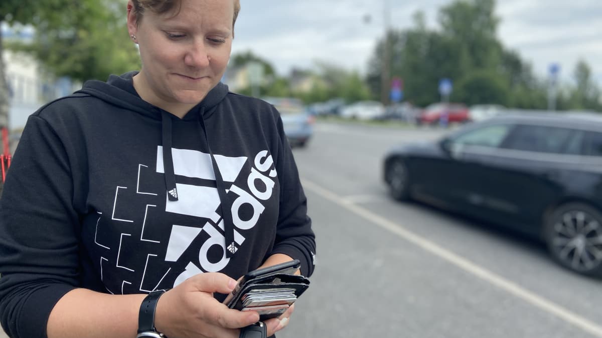 Kuvassa Kuhmoisten kunnanvaltuuston puheenjohtaja Minna Korppila katsoo kännykkäänsä Kuhmoisten keskuskadun varrella. Hän on perustanut Face Bookiin kimppakyytiryhmän