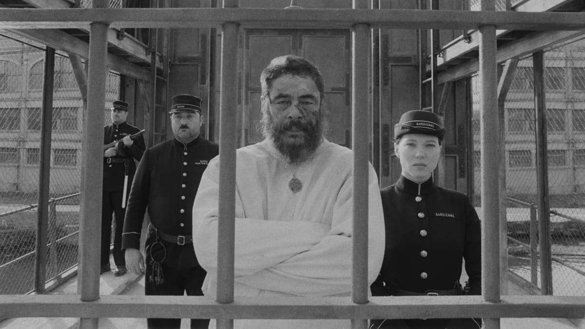 Vanki ja vartijat seisovat kaltereiden takana elokuvan pressikuvassa.