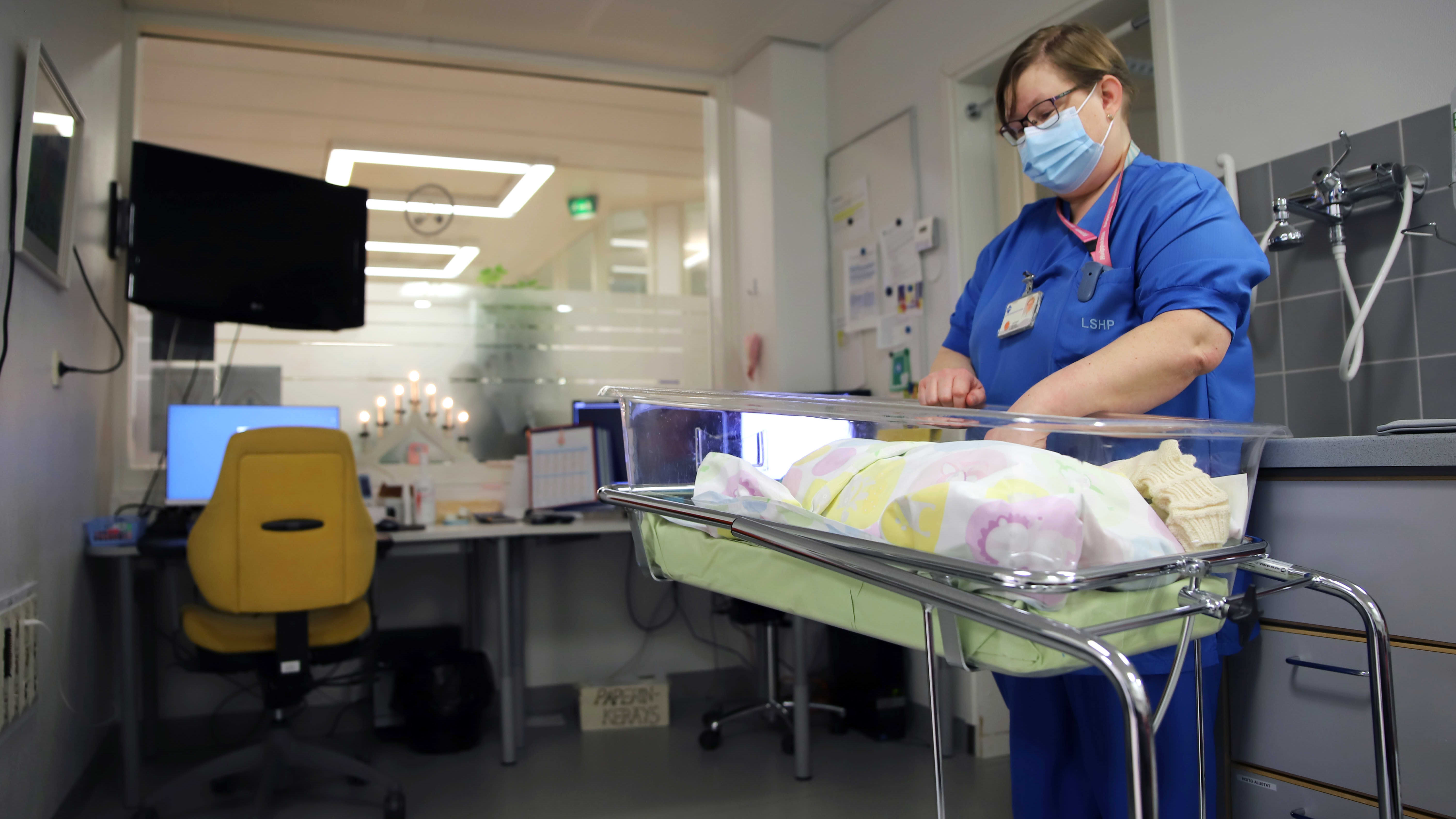 Kätilö Carita Yli-Suvanto Lapin keskussairaalan synnytysosastolla vastasyntyneen sairaalakätkyeen äärellä.