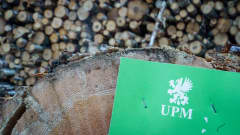 UPM:n logo pahvikortissa tukkipuun päädyssä.