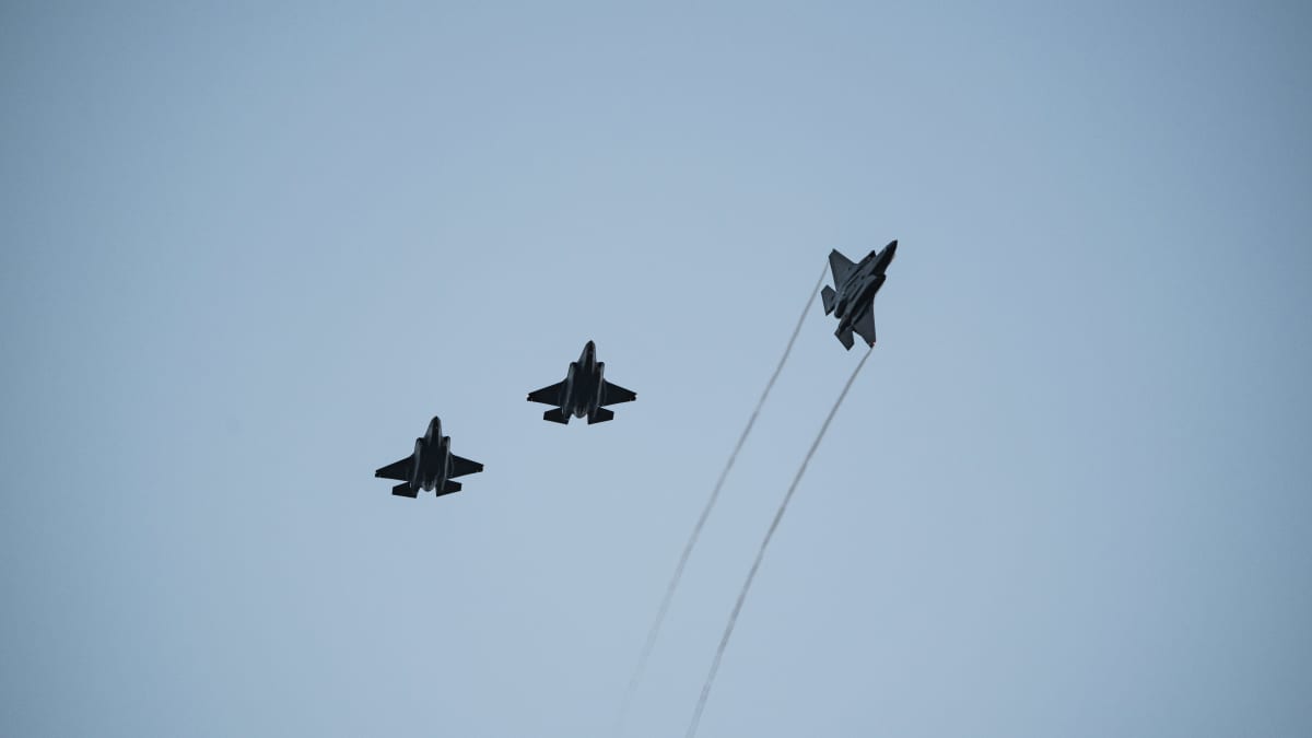 Kolme hävittäjää lentää taivaalla muodostelmassa.