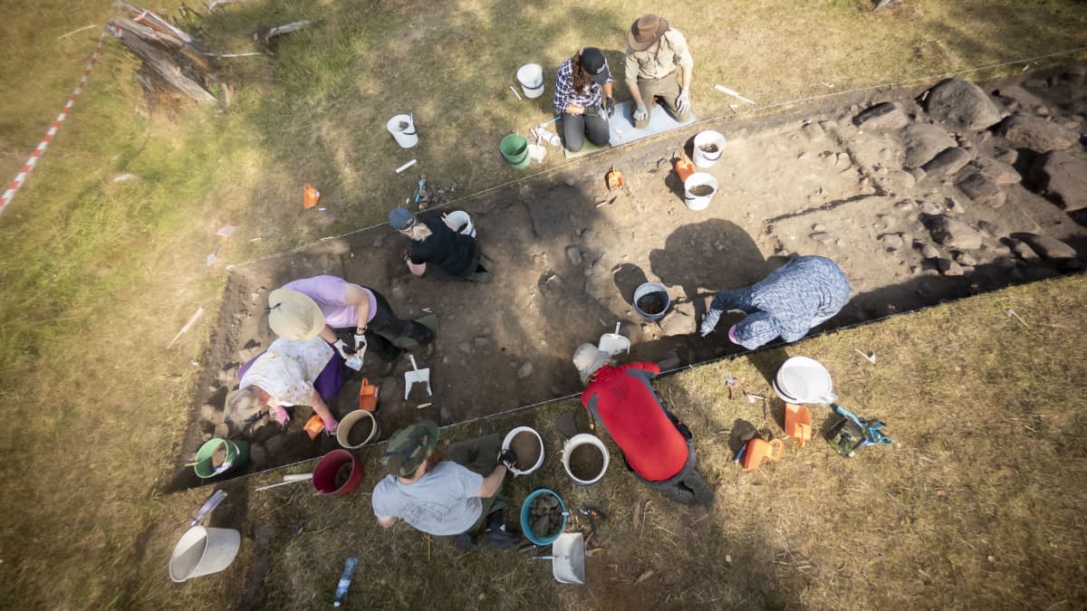 Opiskelijat kaivavat maata arkeologisella kaivauksella.