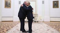 Putin ja Lukašenka halaavat toisiaan valkoisessa salissa.