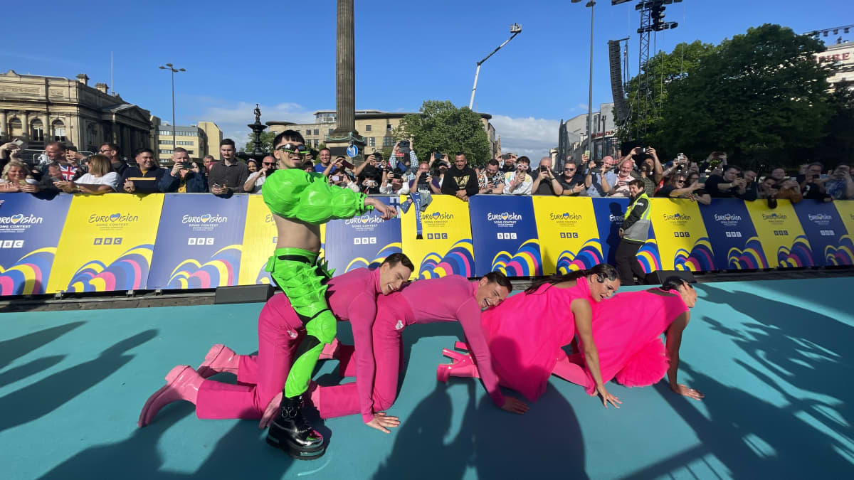 Käärijä ja tanssijat poseeraavat turkoosilla matolla Euroviisujen avajaistapahtumassa Liverpoolissa.
