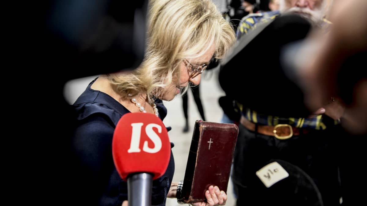 Päivi Räsänen käräjäoikeuden aulassa Raamattu kädessään.