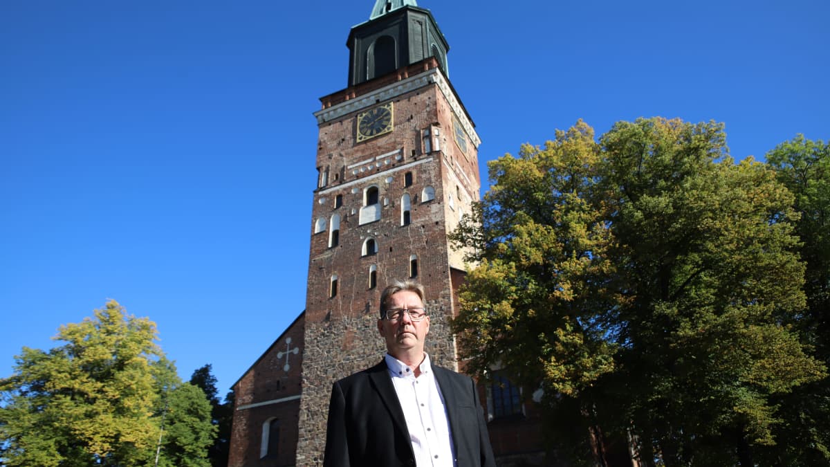 Seppo Kosola seisoo vakavana peruskorjausta odottavat Turun tuomiokirkon edustalla.
