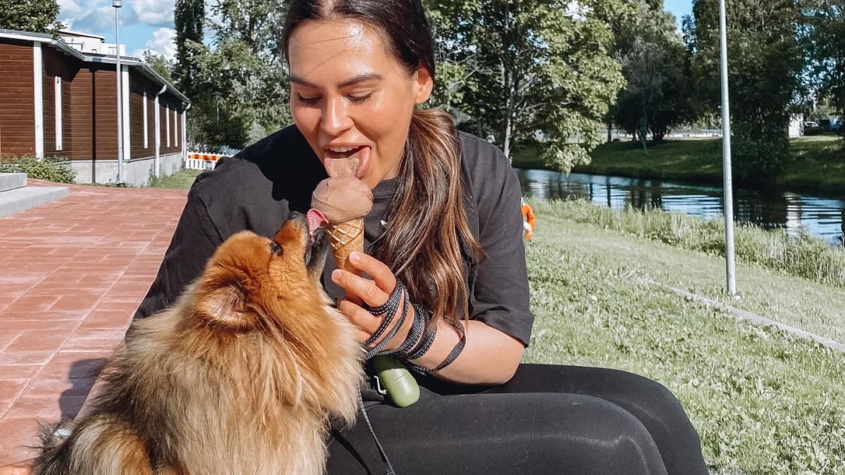 Janette Lepistö syö jäätelöä koiransa kanssa.