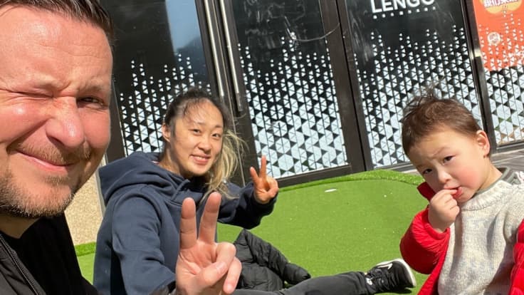 Marko Karsikon perhe istuu ulkona Shanghaissa ja poseeraa kameralle.