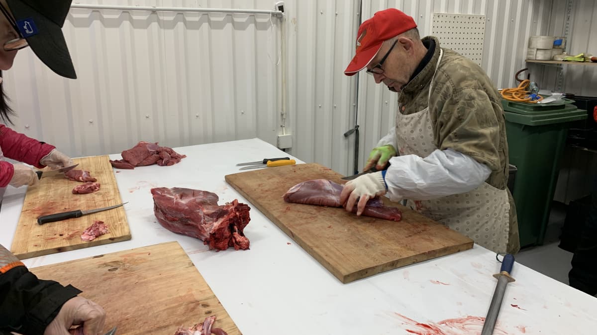 Lihanleikkaaja Esko Puumalainen näyttää Kainuun ammattiopiston kokkiopiskelijoille mallia, kuinka hirvenlihaa leikataan.