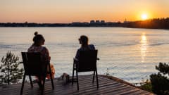 Kaksi henkilö katseleen auringonlaskua Espoon Hanasaaressa.