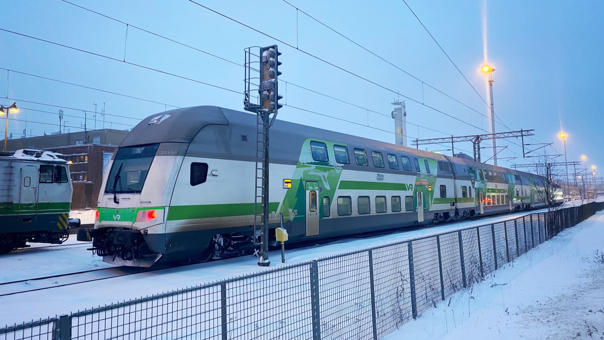 Kaksikerroksinen Intercity-juna Tampereen asemalla. Valkoinen juna, jossa vihreitä raitoja kyljessä. 